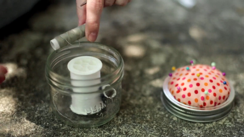 Filling the sewing kit jar with supplies