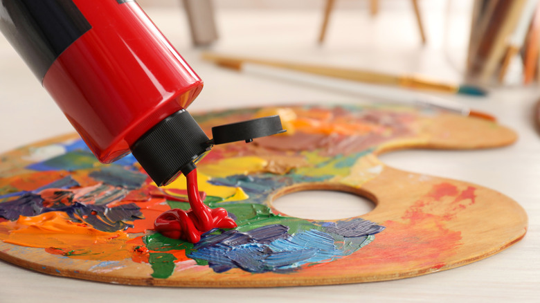 Red paint being poured on a paint palette