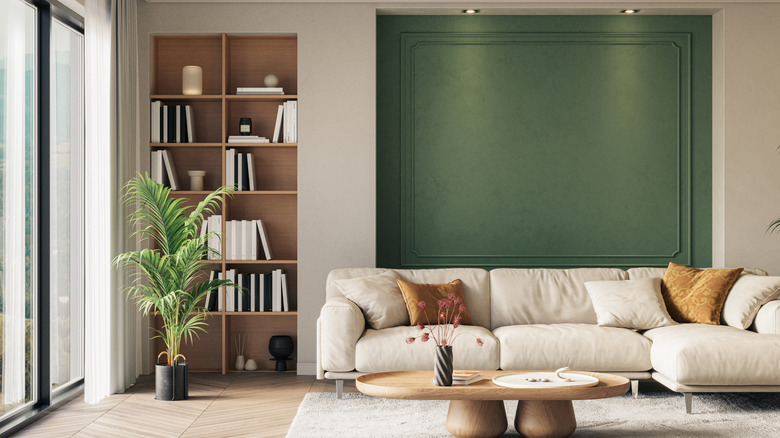 An elegant room decorated in neutral tones, with an accent wall of deeper green.