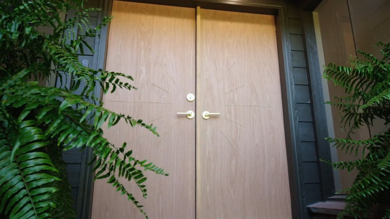A house with a double wooden front door with gold-toned metal accents forming a star shape