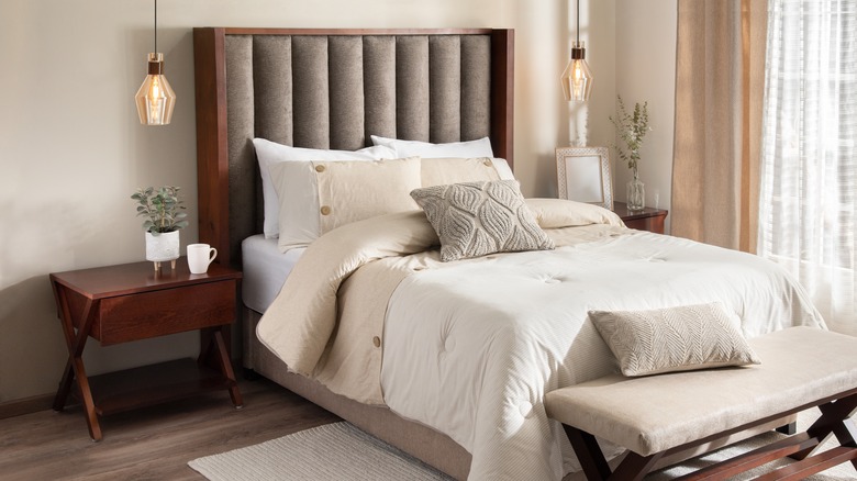 Wood nightstands next to bed with beige sheets