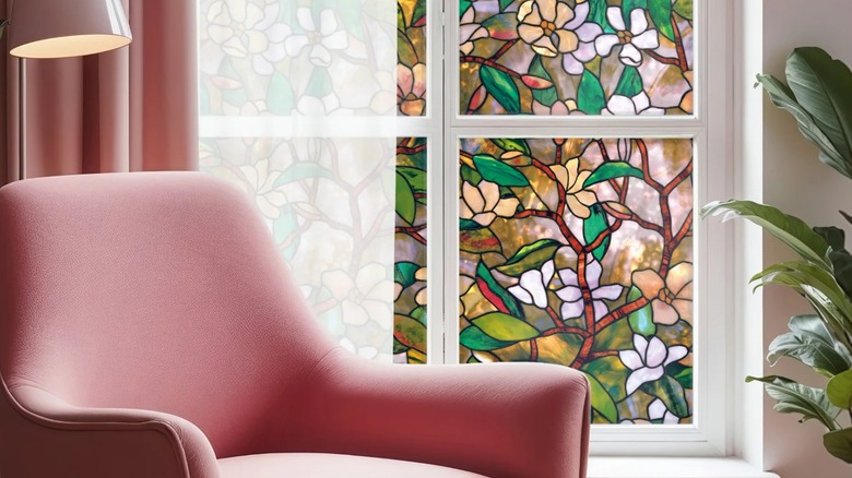 A pink chair sits next to a window covered in ArtScape Magnolia Decorative Window Film