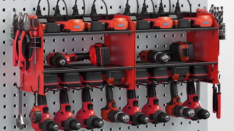 A wall-mounted storage rack with power tools organized on it