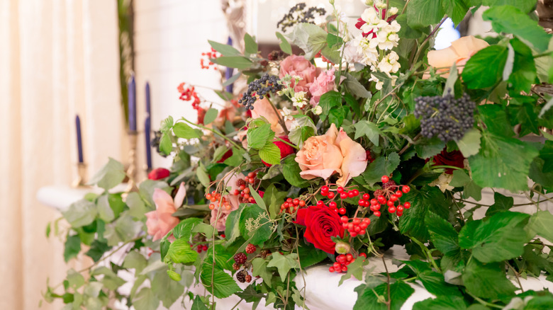 Fireplace mantel with lush floral garland arrangement.