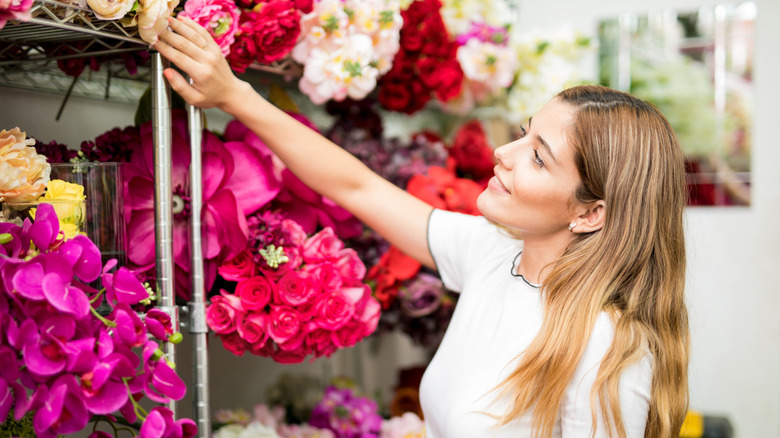 Woman shopping for artificial flowers.
