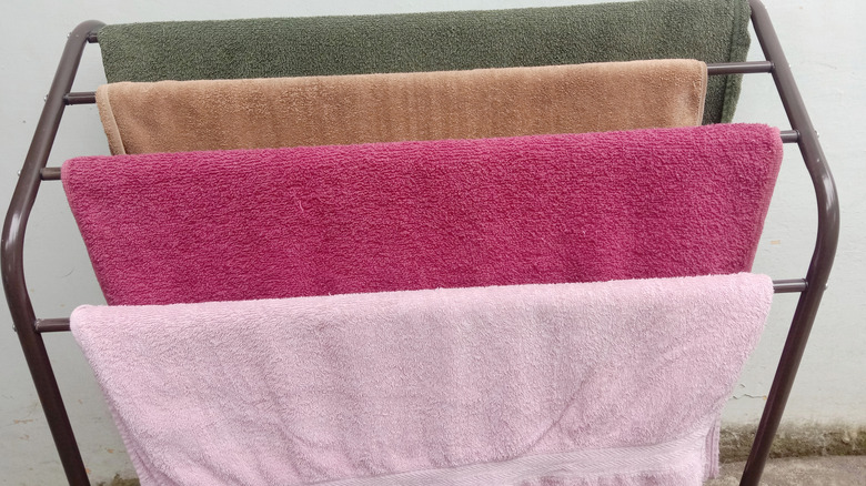 Colorful towels hanging from different bars of a rack