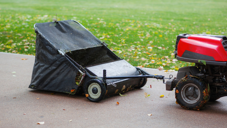 a tow-behind lawn sweeper attached to a vehicle
