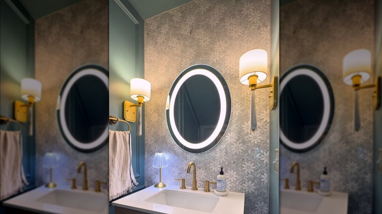 A bathroom sink with a floral mosaic tile backsplash up the wall
