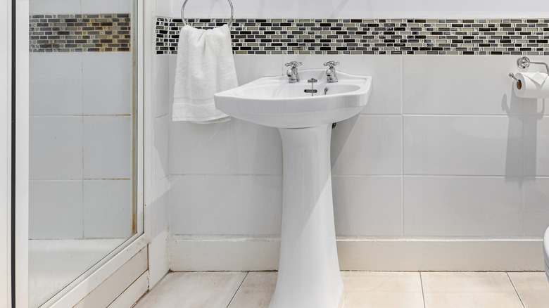 Plain pedestal sink in outdated bathroom