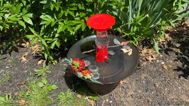 Birdbath made from a hummingbird feeder with a solar fountain