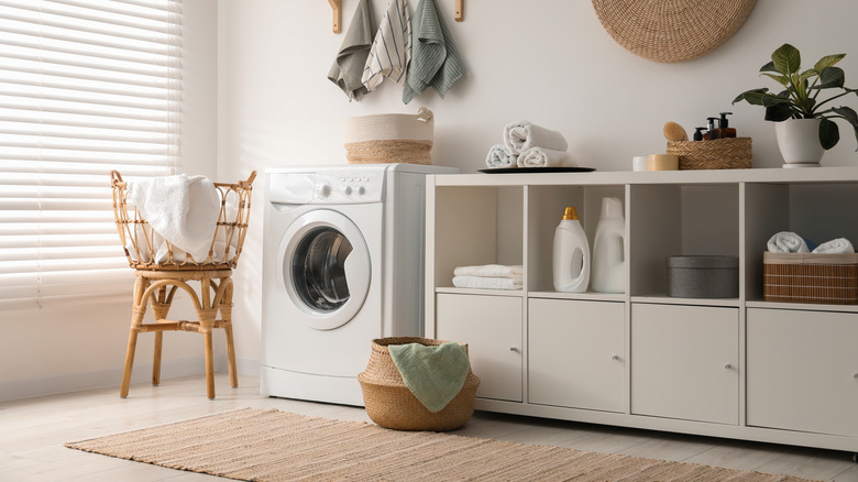 An aesthetic laundry room with washing machine and storage.