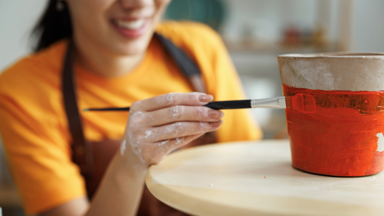 Woman painting plant pot