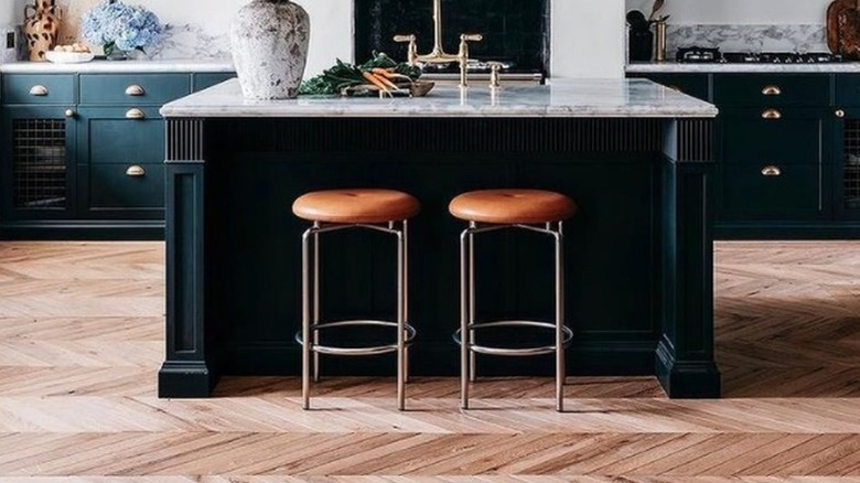 Kitchen with black and marble kitchen island and large plant
