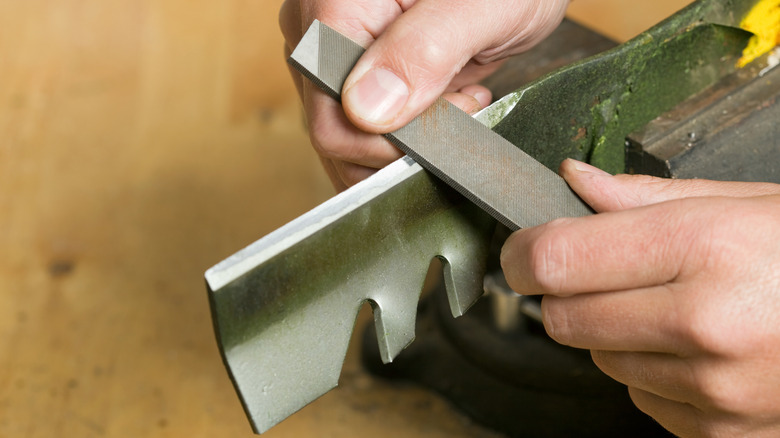 Sharpening a lawn mower blade with a hand file