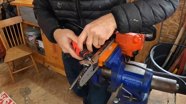 Man using a Sharp Pebble chainsaw sharpener