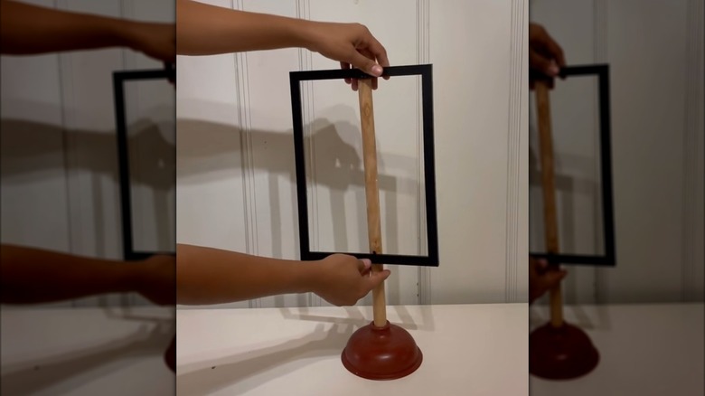 Woman making decor out of Dollar Tree plunger and frame