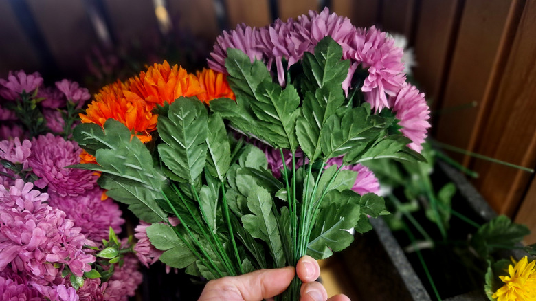 Person holding bunches of fake flowers