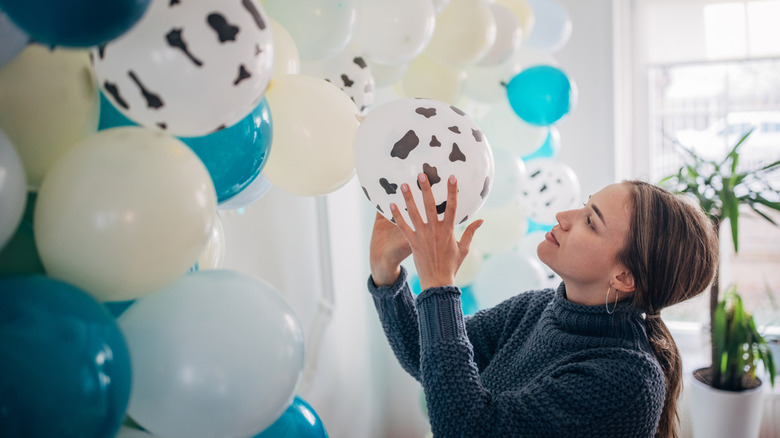 Woman arranging balloons in her home