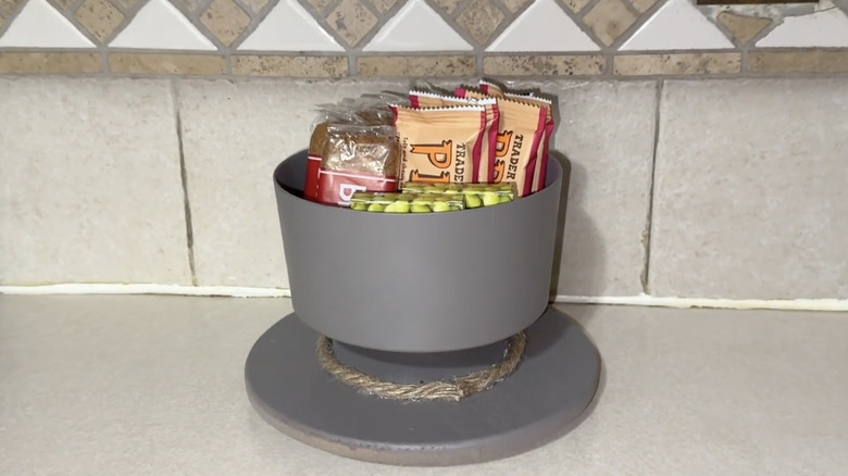 A grey DIY countertop storage with small bags of snacks on a grey/taupe countertop