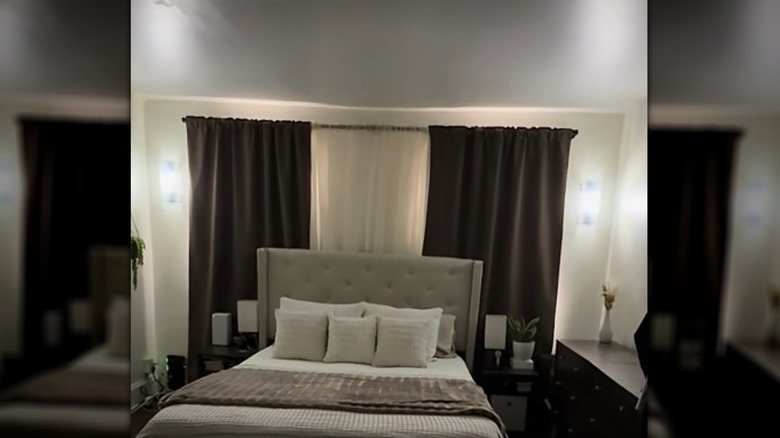 DIY light sconces hanging on the bedroom wall on either side of a window