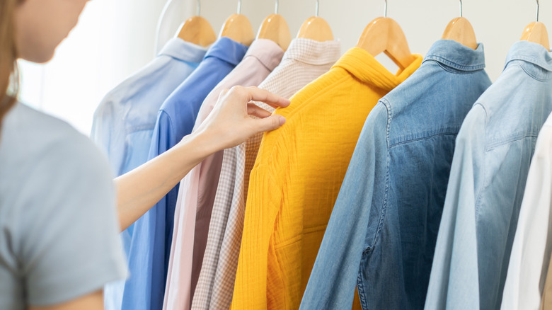 Woman looking at closet full of clothes