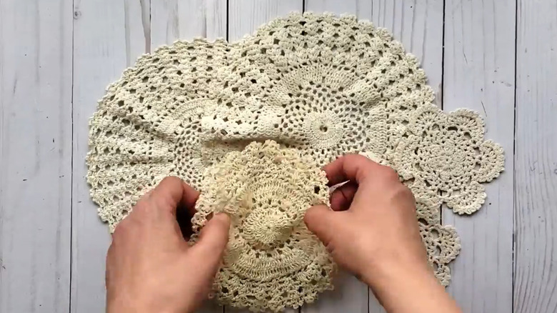 Crafter with a pile of old doilies on a work surface