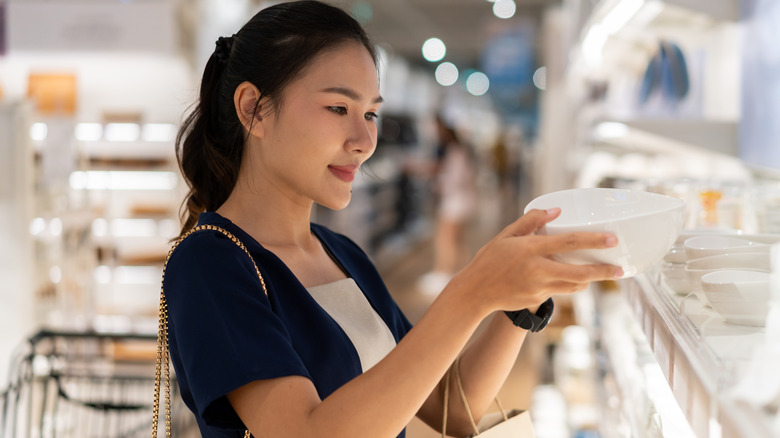 A woman examines a bowl in a store
