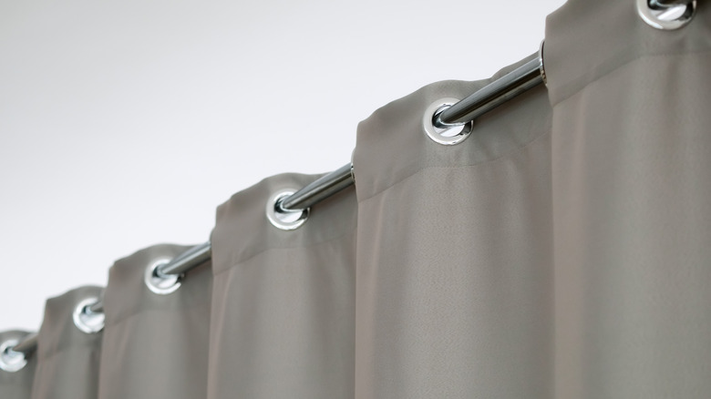 A gray curtain with silver grommets