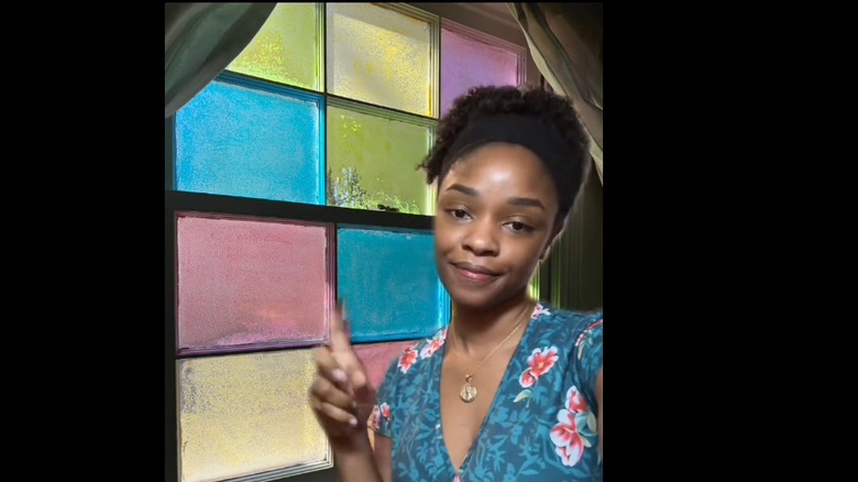 A woman pointing to colorful Elmer's glue window film.
