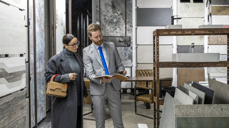 Woman with salesperson shopping for tiles in a showroom