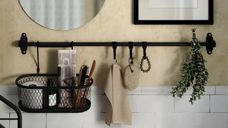 IKEA HULTARP Rail System with container and hooks storing toilet paper, hair tools, and bath essentials