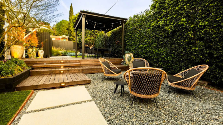 Outdoor seating area on gravel beside a wooden deck