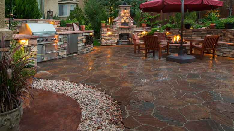 Natural stone patio with a fire pit and outdoor kitchen