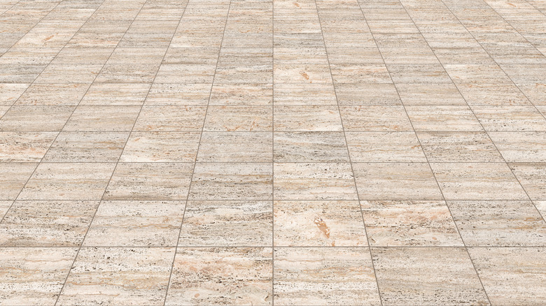 A closeup of a tan travertine paver patio