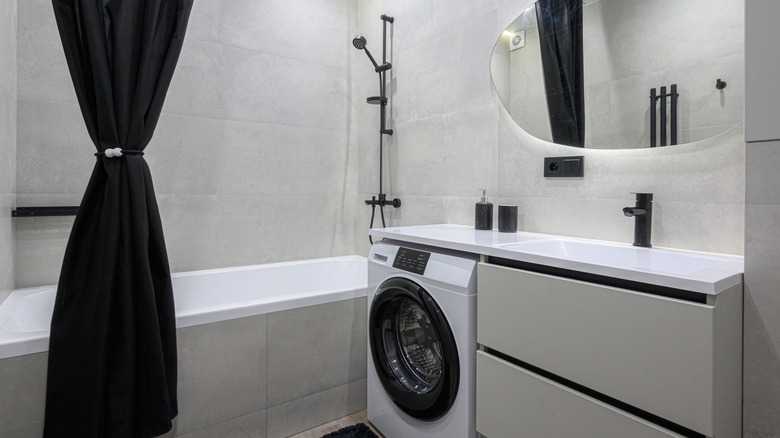 A black fabric shower curtain in a small bathroom