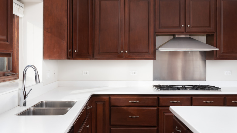 Kitchen with dark cabinets and white countertops