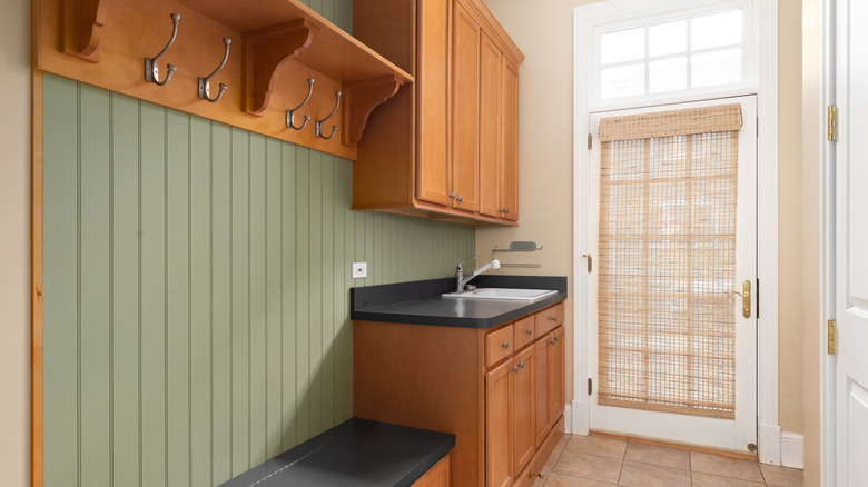 Green painted beadboard wall in mudroom.