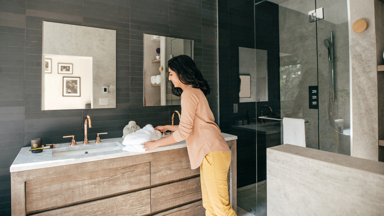 Homeowner cleaning her bathroom vanity topi