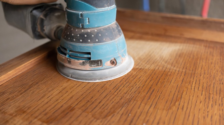 Orbital sander removing finish from oak