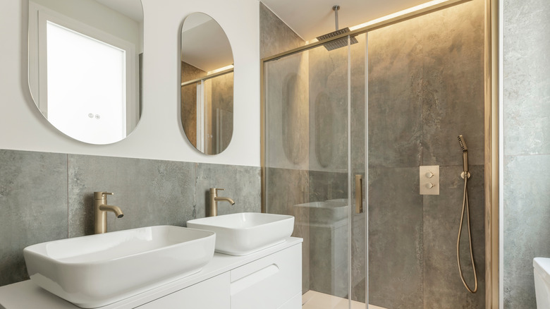 A bathroom with dual sinks and large format tiles in the shower