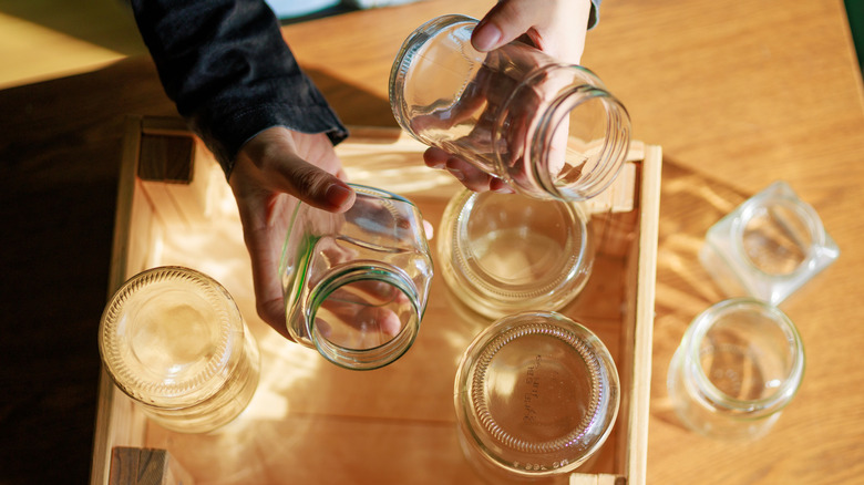 Two hands holding jars