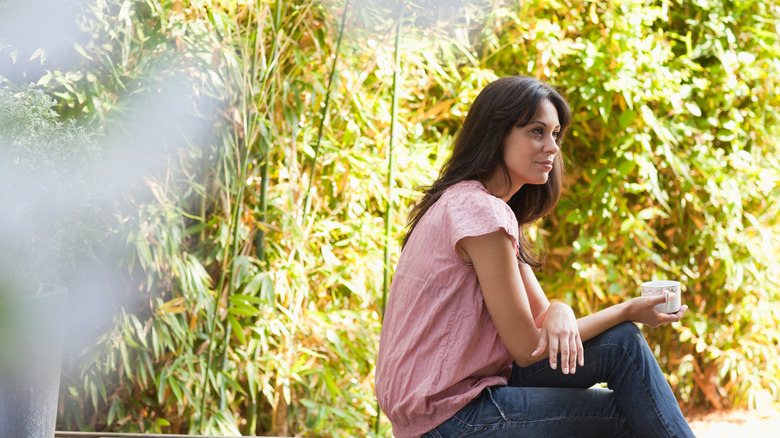 A woman sits on her patio and contemplates