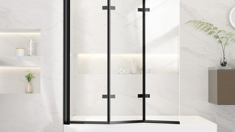 A bathroom with a trifold screen door across the sub