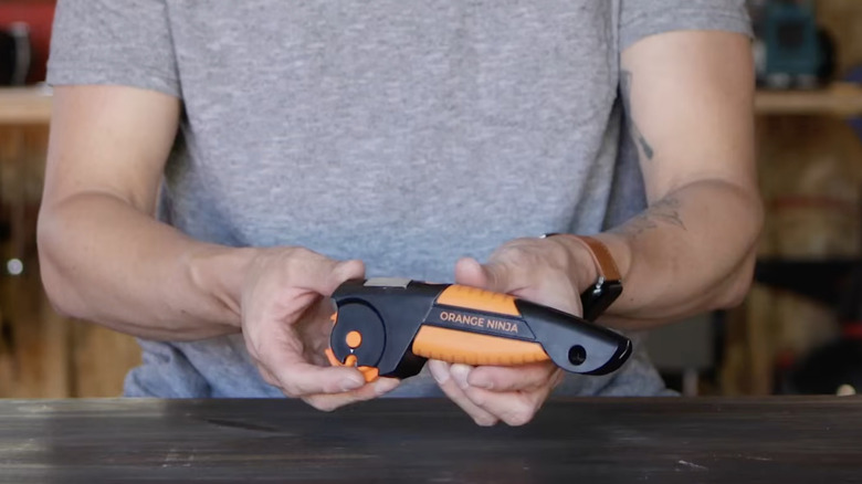 man holding an Orange Ninja sharpening tool