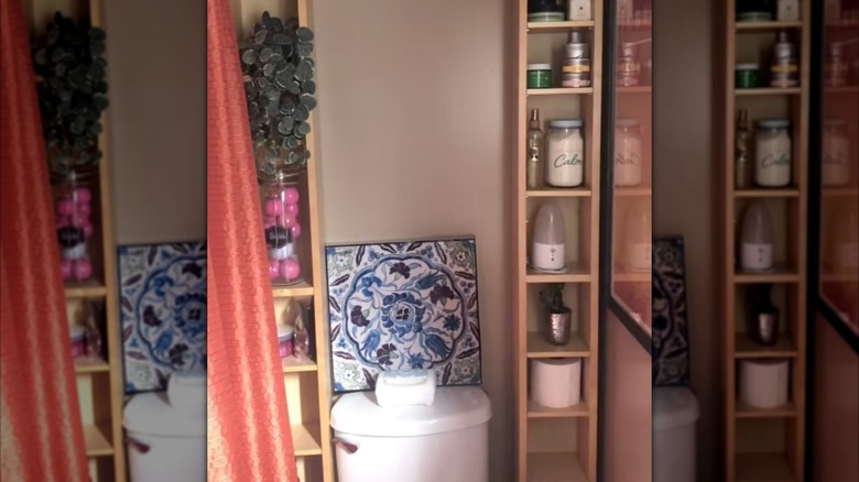 Two GNEDBY shelves from IKEA are arranged on either side of a white toilet