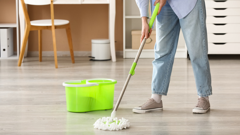 Person wet mopping a wood floor