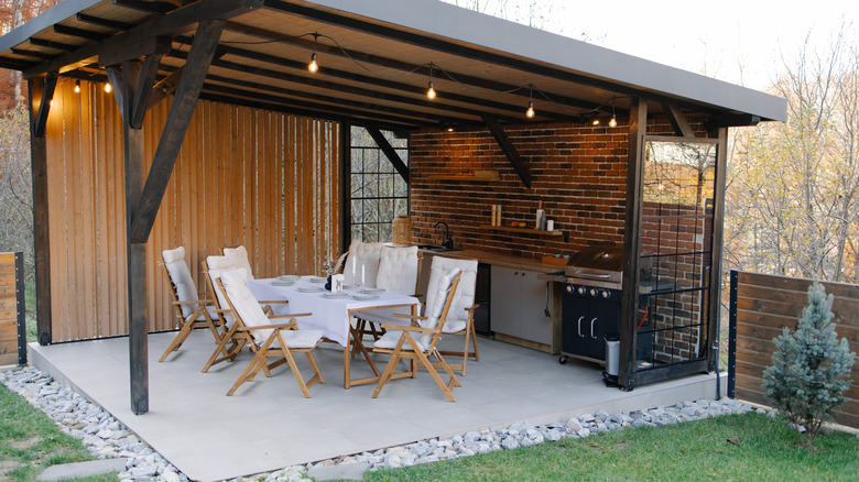 Covered outdoor patio with kitchen and brick wall