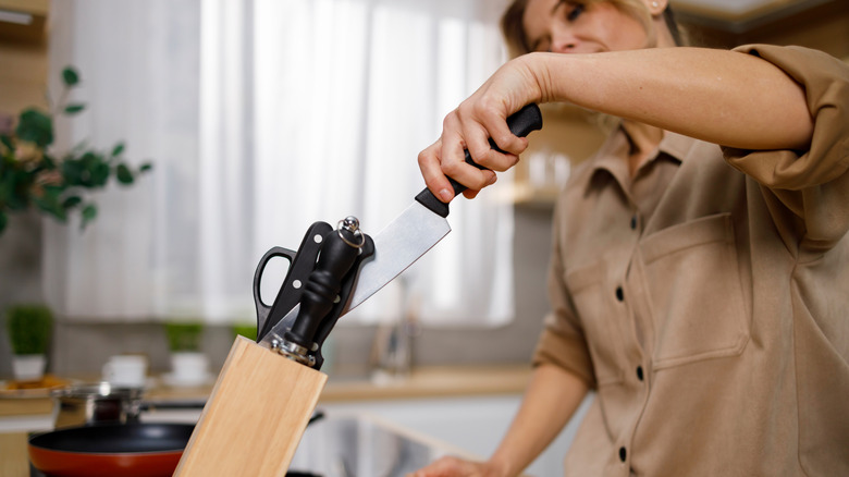 Woman pulling out a knife from her knife stand