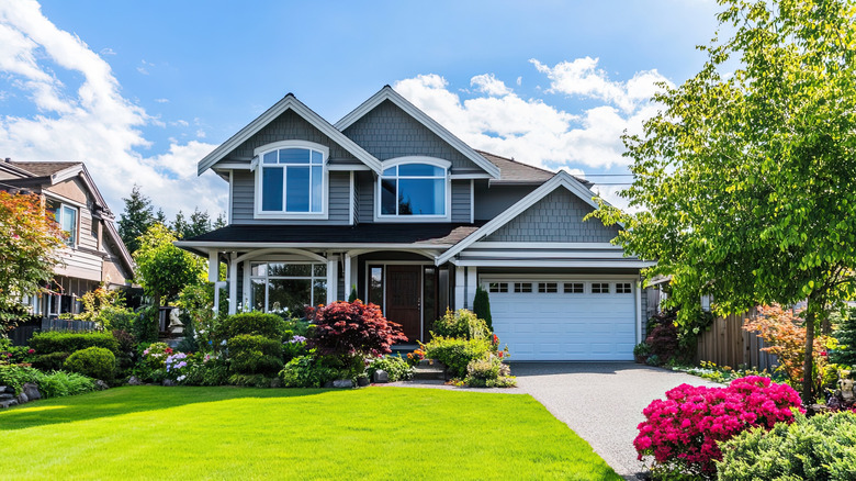 House with driveway lined by flowers