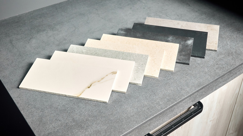 Porcelain countertop samples on a gray, stone-like surface